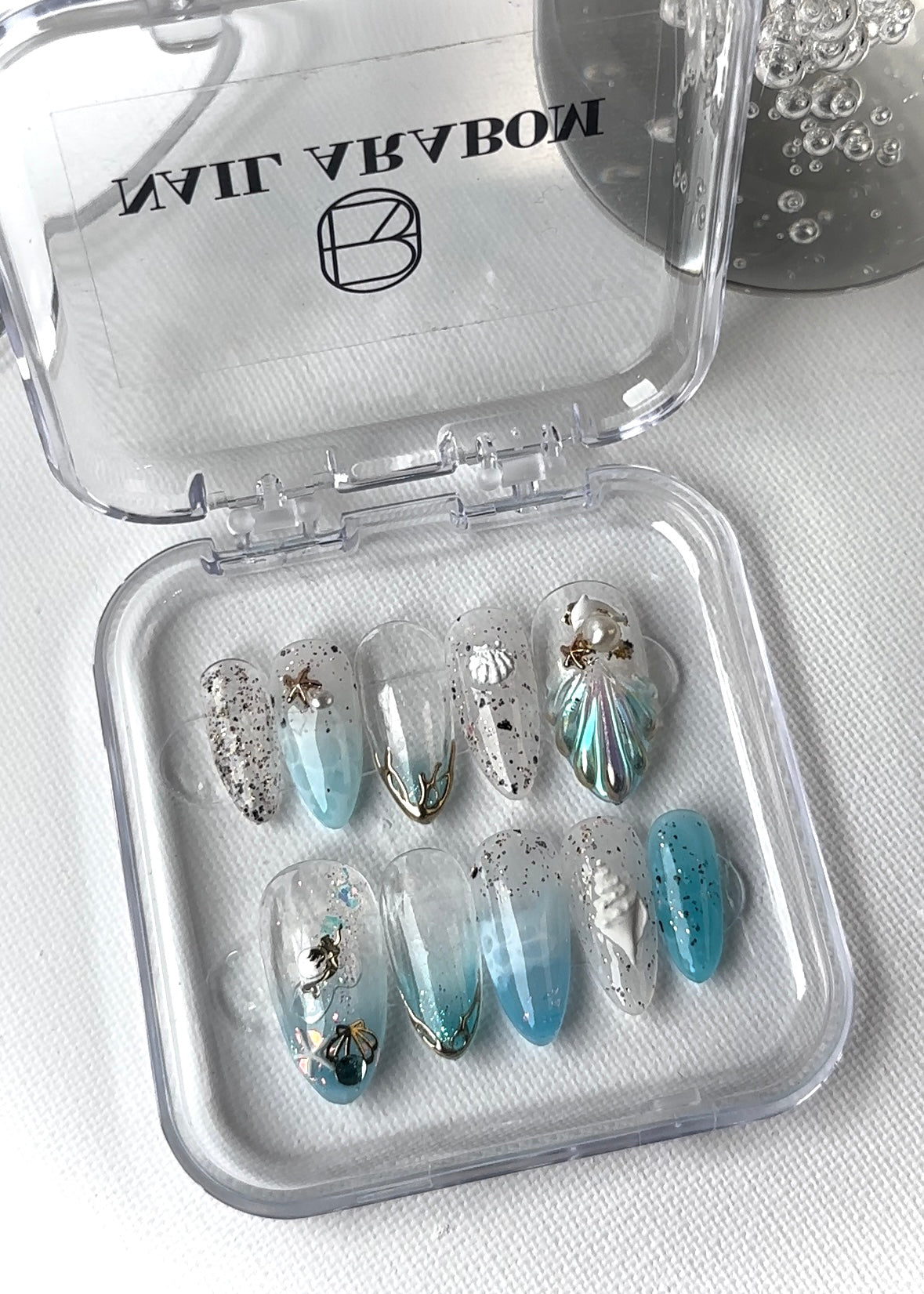 Close-up view of summer collection press-on nails inspired by mermaids