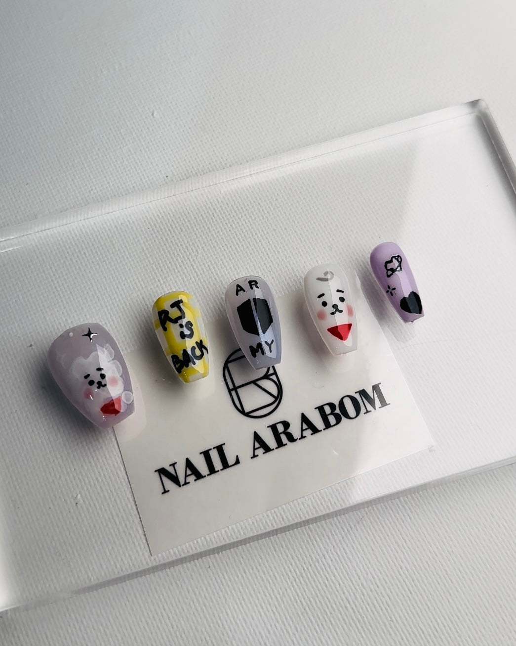 BTS-inspired handmade press-on nails with unique designs for ARMY fans, showcasing high-quality and durable materials.